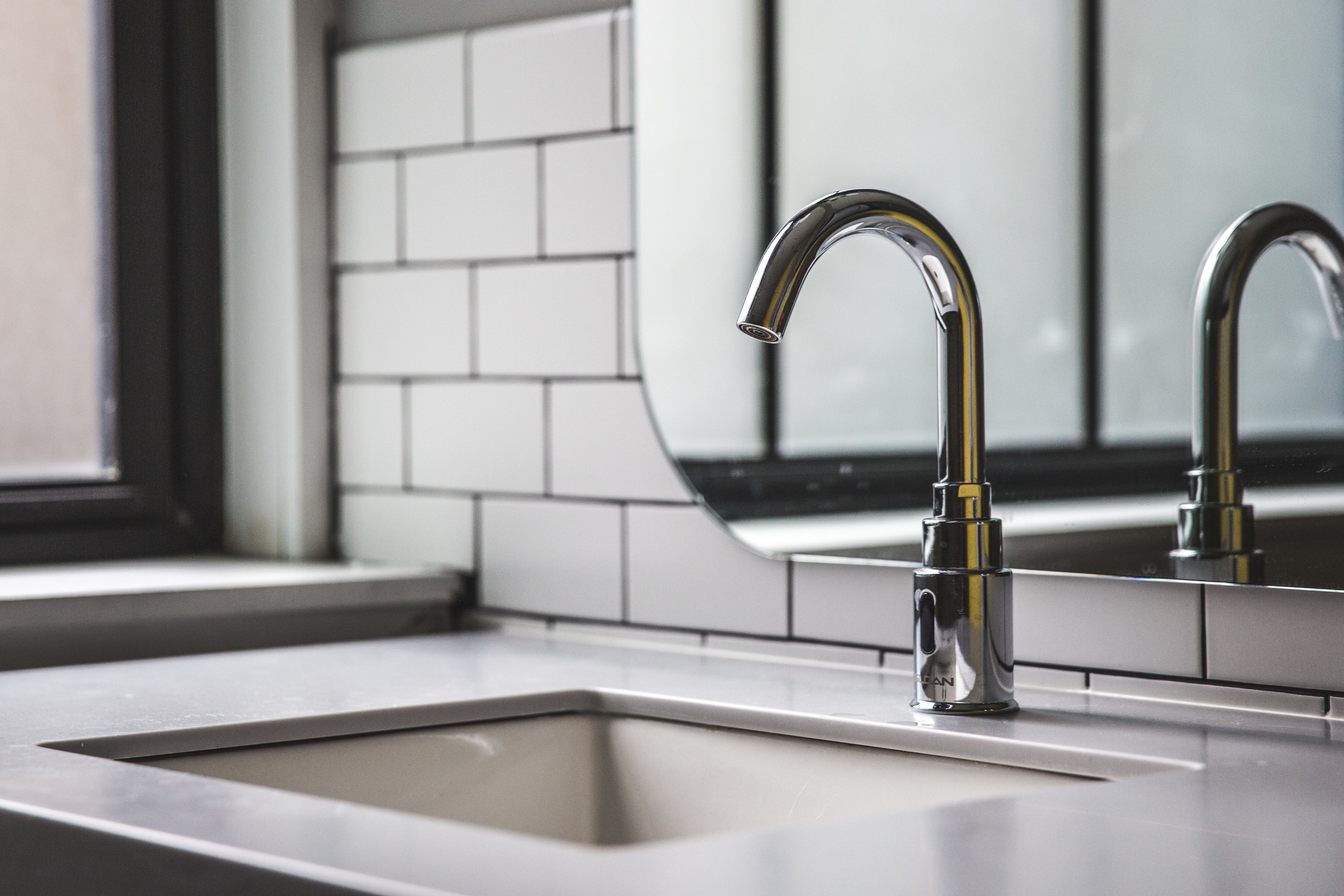 Sleek, modern, and touchless silver bathroom sink faucet.